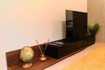 a black entertainment center with a television and a vase at ACOE ASAKUSA - 3 minutes from station in Tokyo