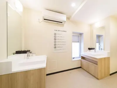 a bathroom with two sinks and a mirror at Super Hotel Shinagawa Aomono-Yokocho in Tokyo