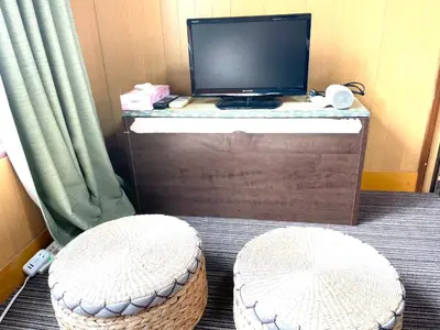 a room with a desk with a computer monitor and two stools at Tokyo Stay Kitashinjyuku in Tokyo