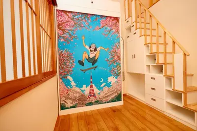 a mural on a wall in a room with a staircase at TokyoKoso Vacation Home in Tokyo