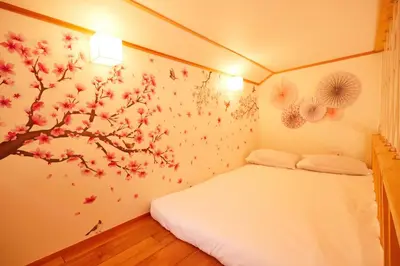 a bedroom with a tree mural on the wall at TokyoKoso Vacation Home in Tokyo
