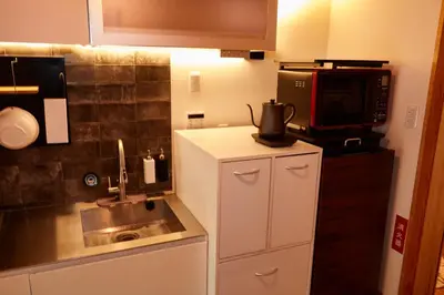 a small kitchen with a sink and a microwave at TokyoKoso Vacation Home in Tokyo