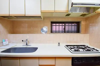 a kitchen with a sink and a stove at Hostel Inn Tokyo Ryogoku in Tokyo