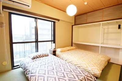 a bedroom with a bed and a large window at Hostel Inn Tokyo Ryogoku in Tokyo