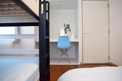 a bedroom with a bunk bed and a blue chair at Hostel Inn Tokyo Ryogoku in Tokyo