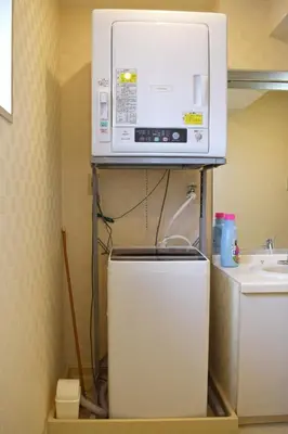 a microwave on top of a refrigerator in a kitchen at Hostel Inn Tokyo Ryogoku in Tokyo