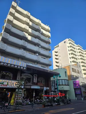a tall building on a city street with buildings at \u7f8e\u30cf\u30a6\u30b9 Beauty House in Tokyo