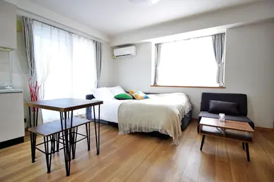 a bedroom with a bed and a table and a chair at ROMANTIC FLAT IN THE HEART OF SHIBUYA / 7MIN WALK in Tokyo