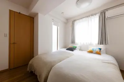 a bedroom with two beds and a window at ROMANTIC FLAT IN THE HEART OF SHIBUYA / 7MIN WALK in Tokyo
