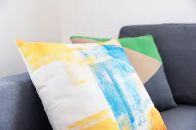 a pillow sitting on a couch with a blanket at ROMANTIC FLAT IN THE HEART OF SHIBUYA / 7MIN WALK in Tokyo