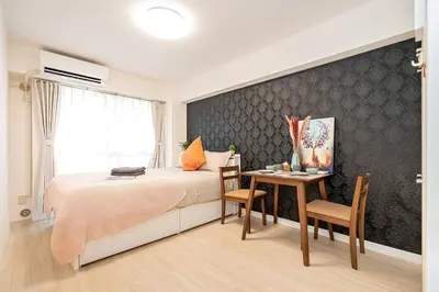 a bedroom with a bed and a table with chairs at \u65b0\u5bbf\u533a\u5e02\u4e2d\u5fc3\u6b4c\u821e\u4f0e\u753a\u9996\u9009\u623f\u6e90\u514d\u8d39Wi-Fi\u3002 in Tokyo
