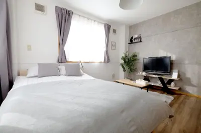 a bedroom with a large white bed and a tv at \u5922\u306e\u820e \u6d45\u8349 Yumenoya Asakusa in Tokyo