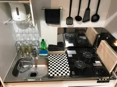 a kitchen with a sink and a stove and utensils at Shinagawa New Apt Easy access to both Haneda & Narita Airport in Tokyo