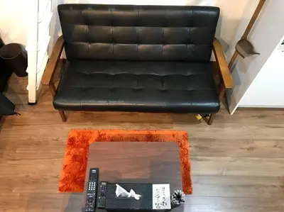 a black leather couch with an orange coffee table at Shinagawa New Apt Easy access to both Haneda & Narita Airport in Tokyo