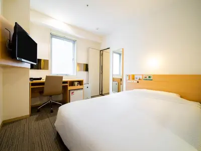a hotel room with a large bed and a desk at Super Hotel Asakusa in Tokyo