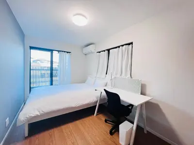 a bedroom with a bed with a desk and a window at Zaki-House-EG0307 in Tokyo