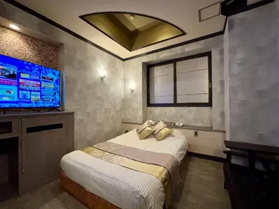 a bedroom with a bed and a flat screen tv at Hotel Crystal -\u5927\u4eba\u5c02\u7528-- in Tokyo