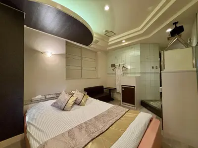 a bedroom with a large bed and a bathroom at Hotel Crystal -\u5927\u4eba\u5c02\u7528-- in Tokyo
