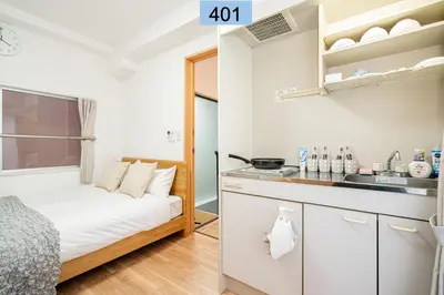 a small bedroom with a bed and a kitchen at Shinjuku area/Family-apartment/4 min to Subway in Tokyo