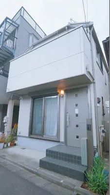 a white house with a door and stairs in front of it at \u6771\u8cc0\u65c5\u9928 in Tokyo