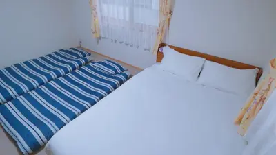 two beds sitting next to each other in a room at \u6771\u8cc0\u65c5\u9928 in Tokyo