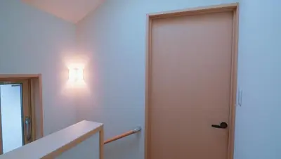 a door in a room with a light on the wall at \u6771\u8cc0\u65c5\u9928 in Tokyo