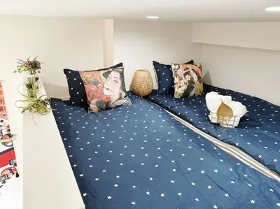 a blue bed with pillows on top of it at Koenji loft apartment/Shinjuku&Kichijoji/JR in Tokyo
