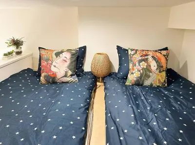 a bedroom with a bed with blue sheets and pillows at Koenji loft apartment/Shinjuku&Kichijoji/JR in Tokyo