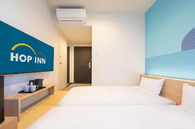 a hotel room with two beds and a hop inn sign at Hop Inn Tokyo Asakusa in Tokyo