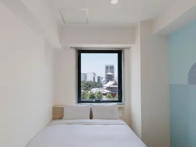 a bedroom with a bed and a large window at Hop Inn Tokyo Asakusa in Tokyo