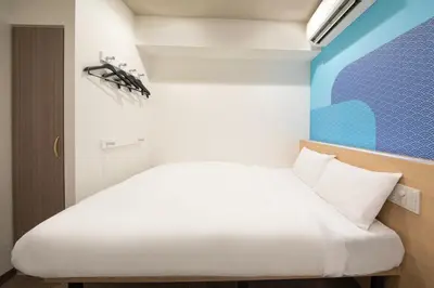 a bedroom with a white bed in a room at Hop Inn Tokyo Iidabashi in Tokyo