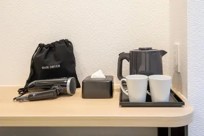 a table with coffee cups and a bag on it at Hop Inn Tokyo Iidabashi in Tokyo