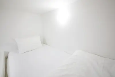 a white bed with a white sheet on top of it at \u30ea\u30a2\u30eb\u9326\u7cf8101 in Tokyo