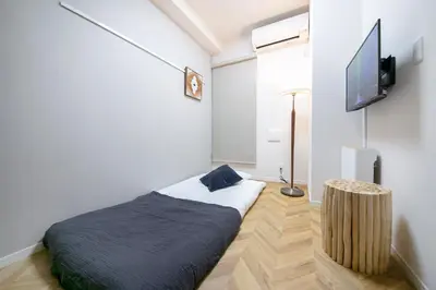 a bedroom with a bed and a flat screen tv at \u30ea\u30a2\u30eb\u9326\u7cf8101 in Tokyo