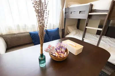 a table with a vase of flowers and a bowl of candy at “1ST ROOM” 内装デザイナー監修！30㎡ 最大6名 経堂駅から徒歩5分 築浅 良質な暮らしを in Tokyo