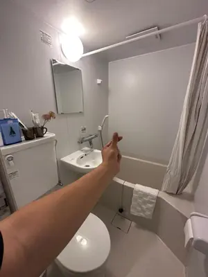 a person pointing to a bathroom with a toilet at Sky house\u6674\u7a7a\u5854106 in Tokyo