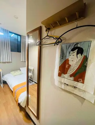 a room with a bed and a painting on the wall at Sky \u6674\u7a7a\u5854 \u72ec\u7acb\u53cc\u4eba\u95f4 \u4f46\u662f\u5171\u7528\u6d74\u5ba4\u5395\u6240105 in Tokyo