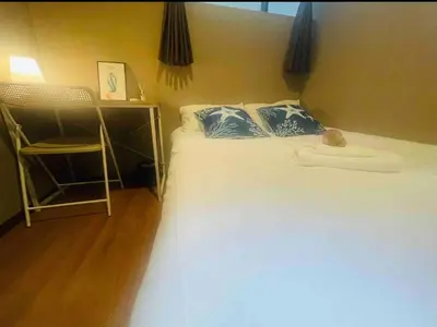 a bedroom with a bed with blue and white pillows at Sky \u6674\u7a7a\u5854 \u72ec\u7acb\u53cc\u4eba\u95f4 \u4f46\u662f\u5171\u7528\u6d74\u5ba4\u5395\u6240105 in Tokyo