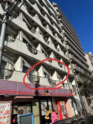 a tall building with a red circle on the side of it at \u5e73\u548c\u5c9b\u6c11\u5bbf in Tokyo