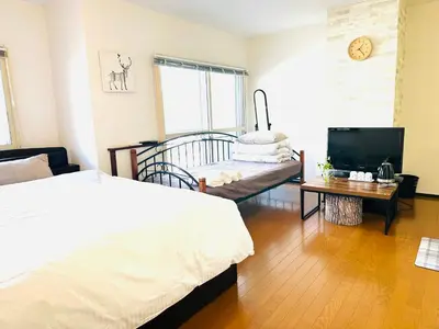 a bedroom with two beds and a television in it at \u5e73\u548c\u5c9b\u6c11\u5bbf in Tokyo