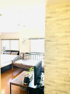 a room with two beds and a computer on a desk at \u5e73\u548c\u5c9b\u6c11\u5bbf in Tokyo