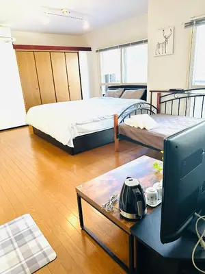 a room with two beds and a desk with a computer at \u5e73\u548c\u5c9b\u6c11\u5bbf in Tokyo