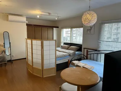 a room with a bed and a table and a room with two beds at \u5e73\u548c\u5c9b\u6c11\u5bbf in Tokyo