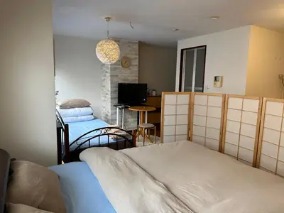 a bedroom with two beds and a tv in it at \u5e73\u548c\u5c9b\u6c11\u5bbf in Tokyo