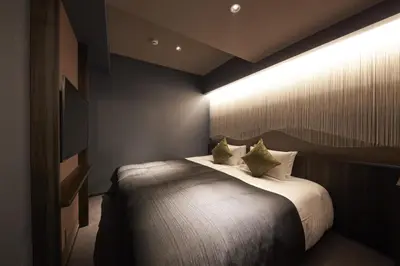 a bedroom with a large bed with pillows at SAKE Bar Hotel Asakusa in Tokyo