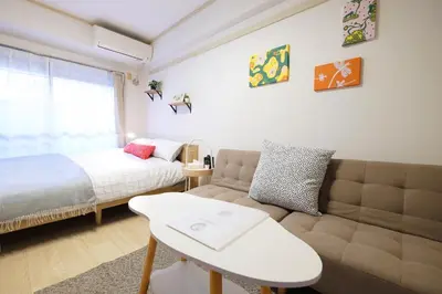 a bedroom with a bed and a couch and a bed and a window at \u5922\u306e\u820e \u65b0\u5bbf Yumenoya Shinjuku in Tokyo