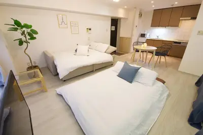 a living room with two beds and a kitchen at PALAIS GRACE 301 in Tokyo