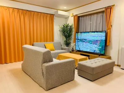 a living room with two chairs and a large screen tv at Kamei House - Vacation STAY 07100v in Tokyo