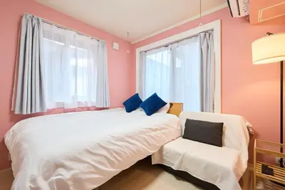 a bedroom with a white bed and a chair at Shinjuku colorbee pretty house103 in Tokyo