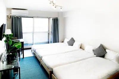 a living room with two beds and a window at Shinjuku central apartment! 3stops to Shibuya station 3mins walk to station in Tokyo
